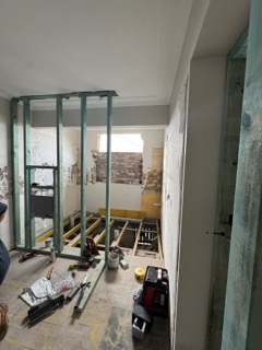 Forming independent service walls separating the bath and laundry zones.