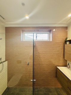 Master bathroom featuring custom wall-hung timber vanity and concealed cistern toilet.
