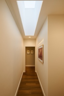 Transition hallway featuring recessed display niche with warm 2700K concealed LED lighting.