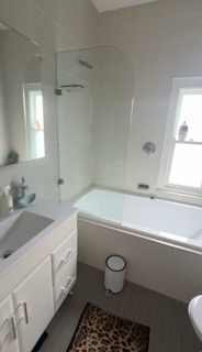 Original unventilated bathroom with awkward shower-over-bath.